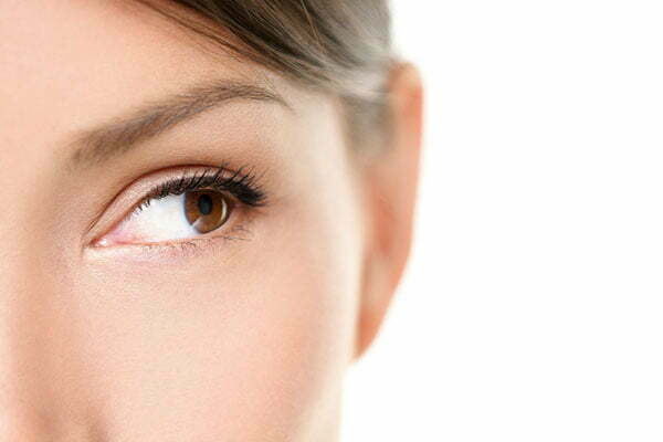 Eye close up - brown eyes looking to side isolated on white back