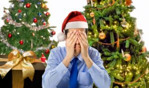 Stressed man is shopping gifts for christmas with red santa hat angry and distressed