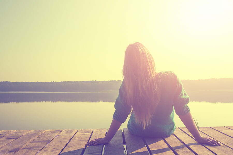 woman sitting by the lake