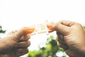 two hands holding puzzle pieces